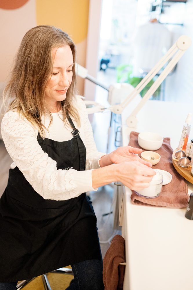 An esthetician mixes Éminence masques at the facial bar