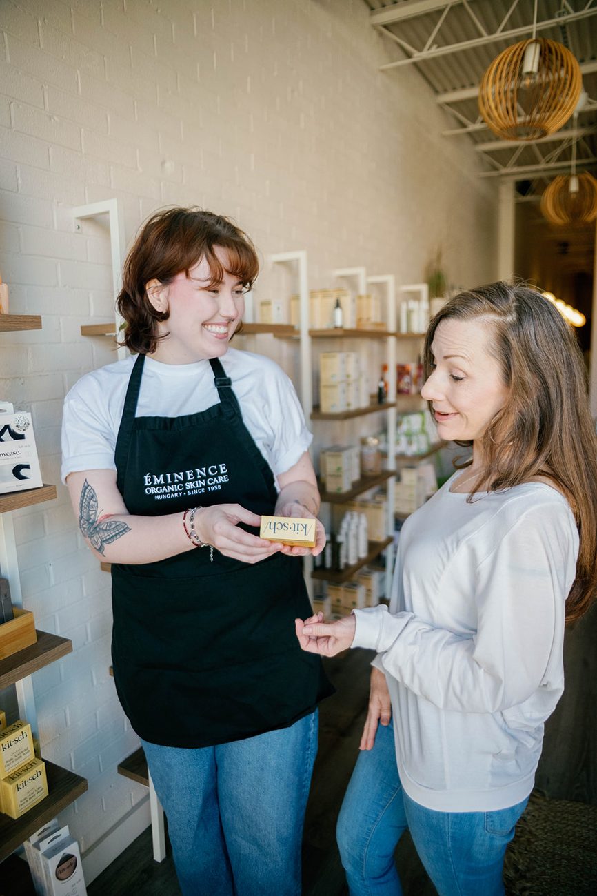 A Mia June esthetician shares product picks with a smiling guest